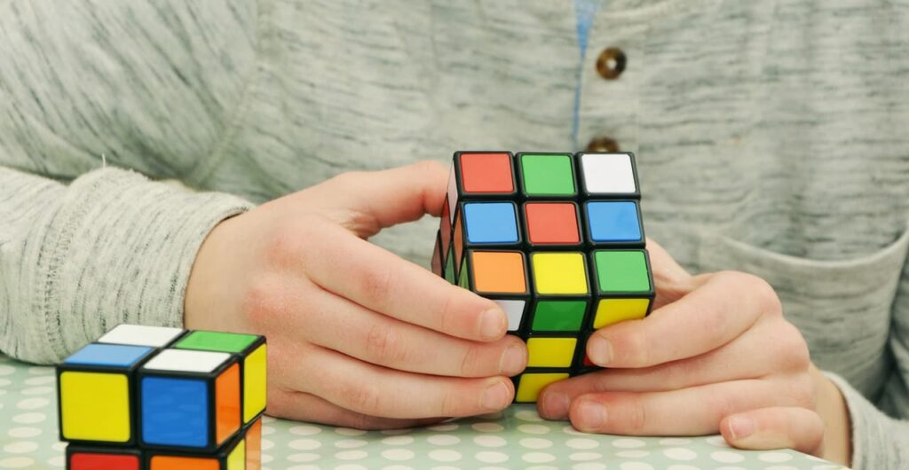 Man solving rubik cube showing problem solving skills.